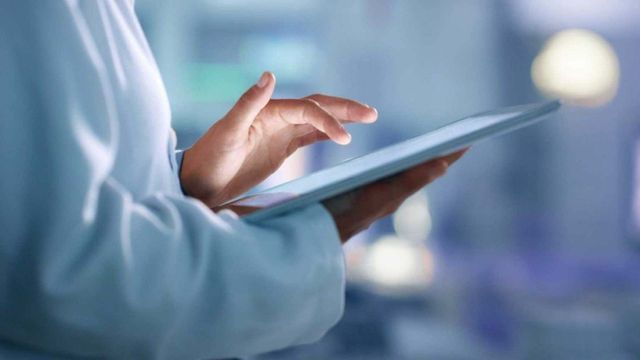 Researcher using a digital tablet as an AI lab notebook in a modern laboratory setting. 