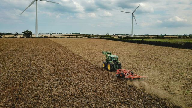 A tractor plowing a harvested field. 