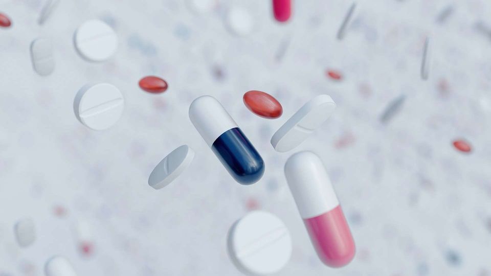 Various capsules and tablets pictured as if falling from a height, against a white background.
