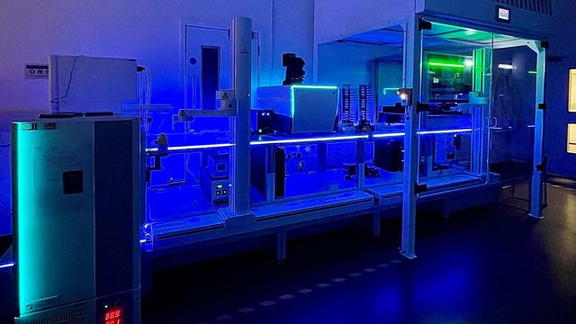 AI lab infrastructure with automated laboratory equipment and blue LED-lit workstations. 