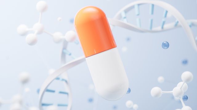 Illustration of an orange and white drug capsule surrounded by a DNA double helix and stick and ball models.  