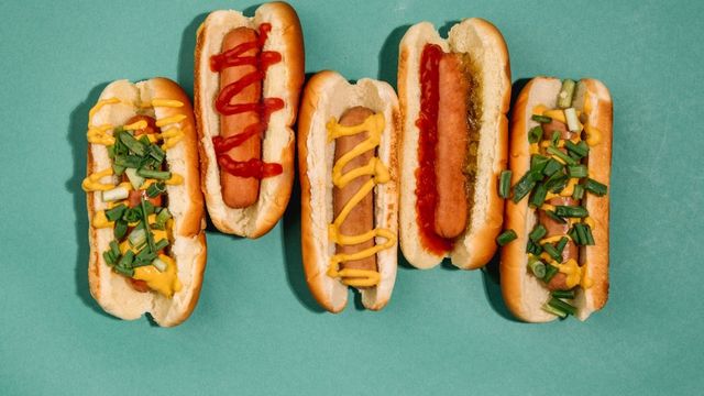 Five hotdogs side-by-side, each with different toppings. 