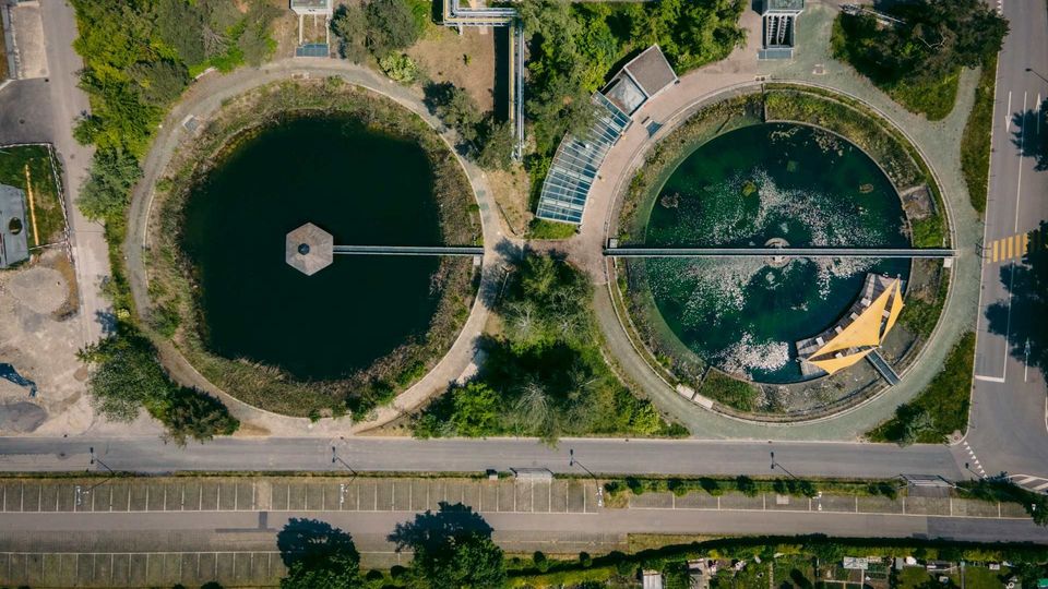Aerial view of a sewage treatment plant with circular clarifier tanks and filtration basins.