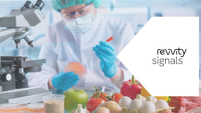 Scientist testing food samples in a lab with fresh produce, illustrating food safety analysis. 