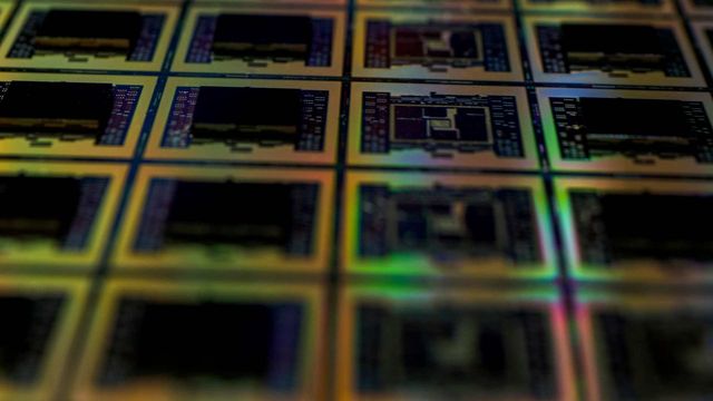 Silicon wafer with multiple semiconductor chips used in microchip manufacturing. 