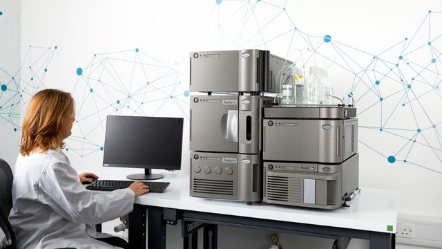 Mass detection lab balance measuring a metal calibration weight in an enclosed chamber. 