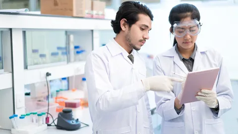 Lab scientists review tablet for drug discovery decisions with unified bio and chemical data.
