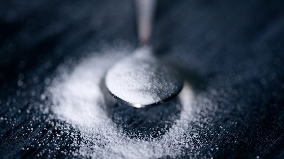 White powdered sweetener on a spoon.