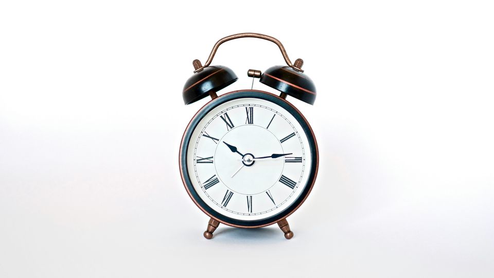 The face of an old-fashioned bell alarm clock against a white background.