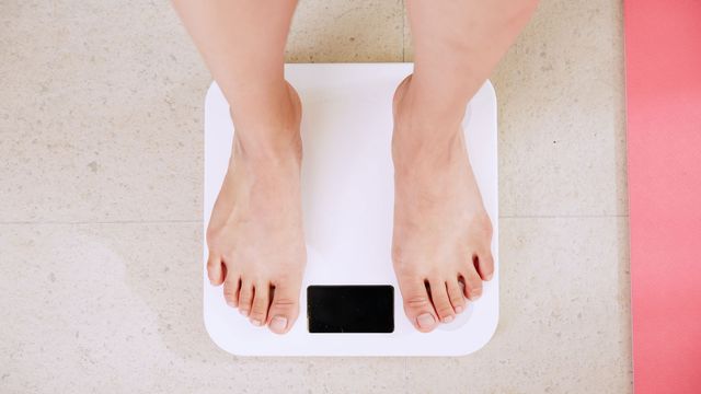 A person's feet on a set of bathroom scales. 
