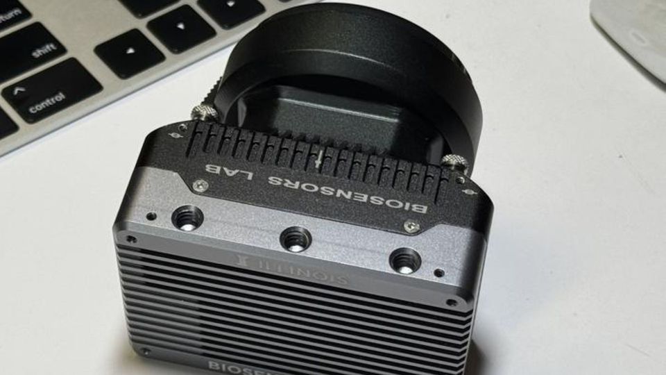 Integrated biosensor camera device on desk, showcasing compact lab imaging technology.