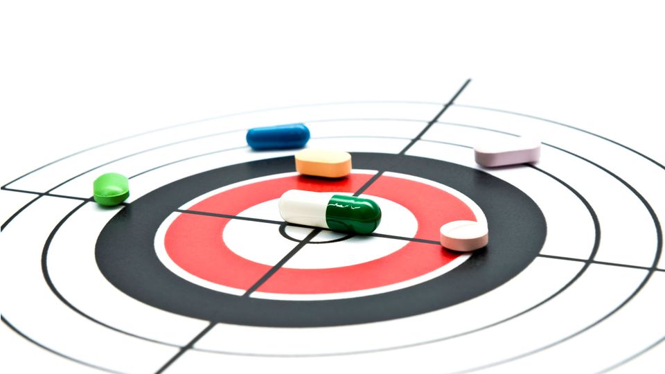 Various drugs on a target board, representing screening in drug discovery.