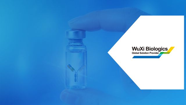 Antibody drug conjugate vial held in gloved hand with WuXi Biologics logo. 