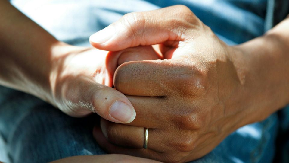 Close-up of two hands clasped together.