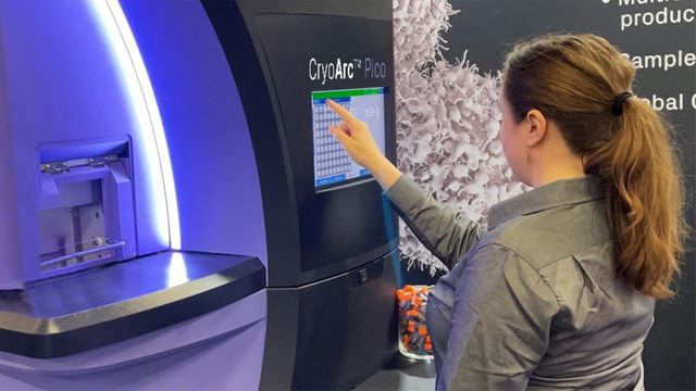 Woman operating CryoArc Pico lab instrument via touchscreen. 