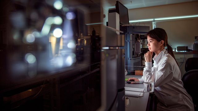 Scientist analyzing samples at lab workstation with advanced instrumentation. 