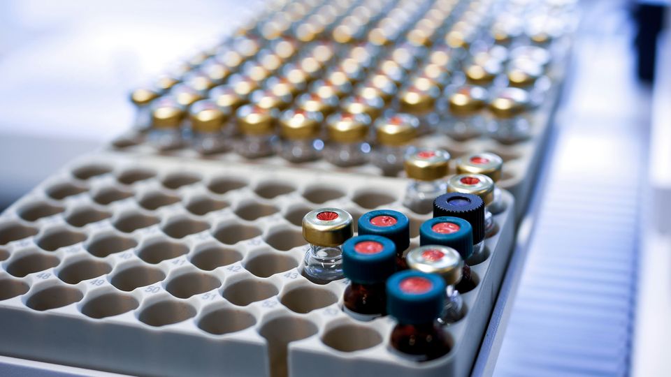 Transparent and amber compound vials stored in numerically labeled rows.