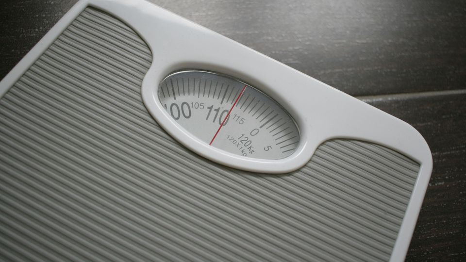 Birds-eye-view of a weighing scale, showing a red dial over the numerical reading.