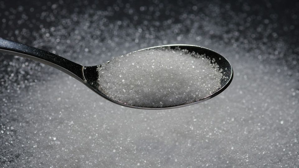Close-up of a spoon filled with sugar crystals.