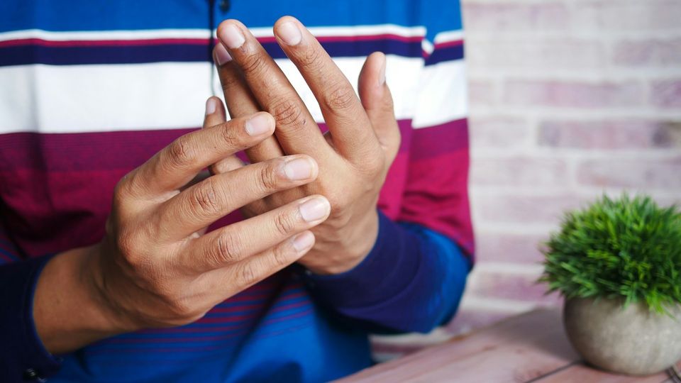 Close-up of a person's hands as they hold and pressing their fingers.