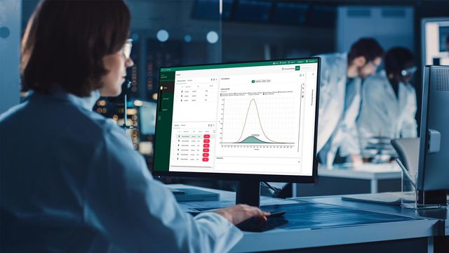 Scientist reviewing chromatography analysis data on a desktop monitor in a modern laboratory setting 
