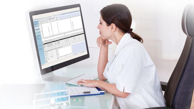 Scientist reviewing chromatography data and analytical results on laboratory software displayed on a desktop computer monitor. 