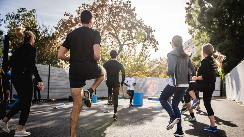 A group of people in an exercise class in the sunshine.