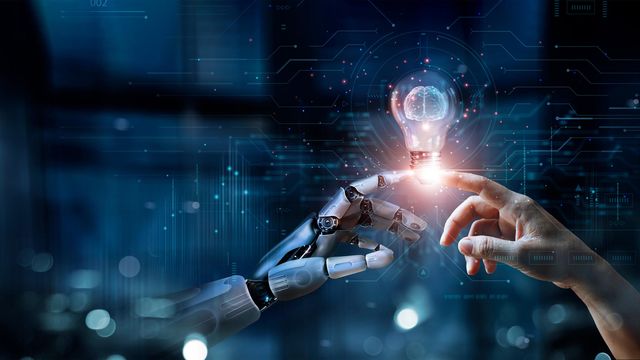 Robot and human hand touching with lightbulb. 