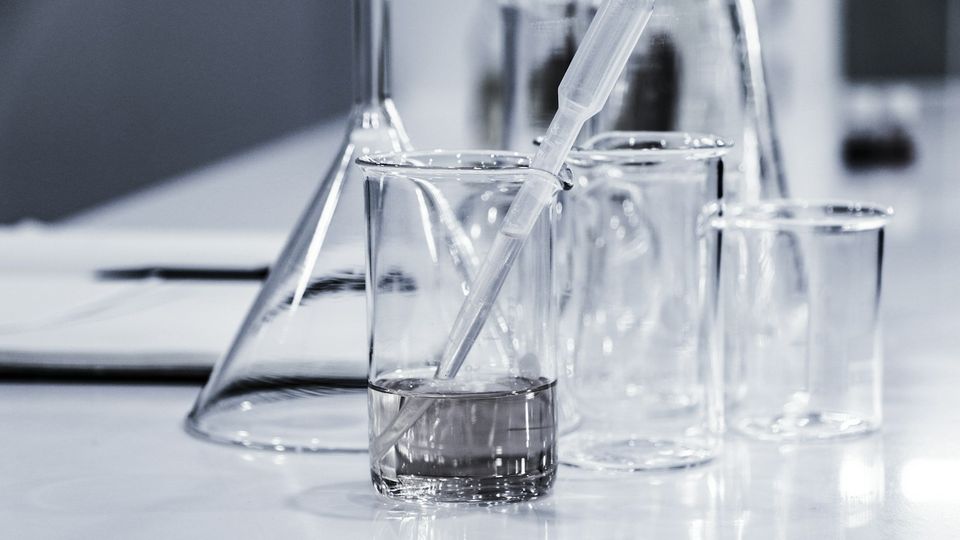 Laboratory beakers and pipette on a lab bench.