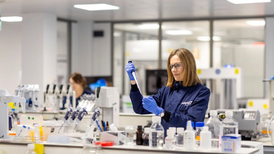 Scientist using a pipette in a laboratory.
