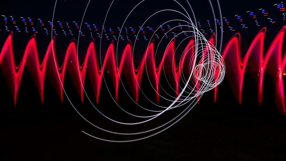 Abstract red laser light pattern with concentric rings and waveforms.