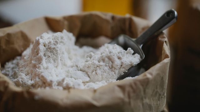 Scoop in a bag of flour with fine white baking flour piled inside. 