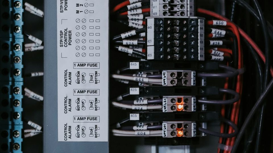 Electrical control panel with labeled wires, terminal blocks, and illuminated status indicators.