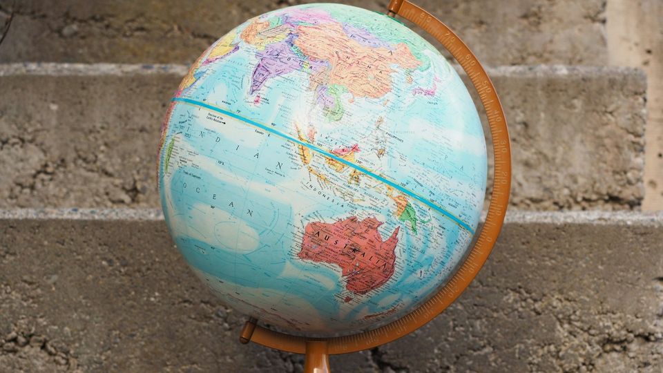Globe on concrete stairs displaying Australia and Asia.