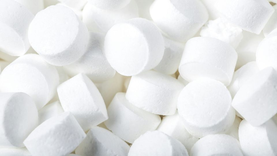 A close-up of many round white pills.