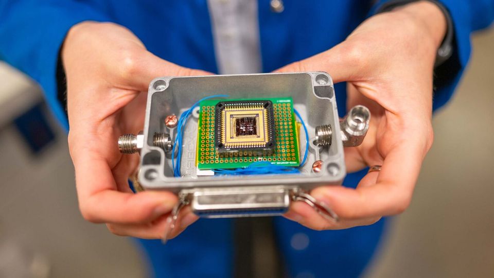A photograph of the electronic nose system. It is an electronic chip and motherboard, housed in a gray metal case.