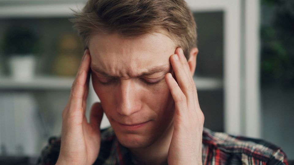 Man holding his temples with a headache.