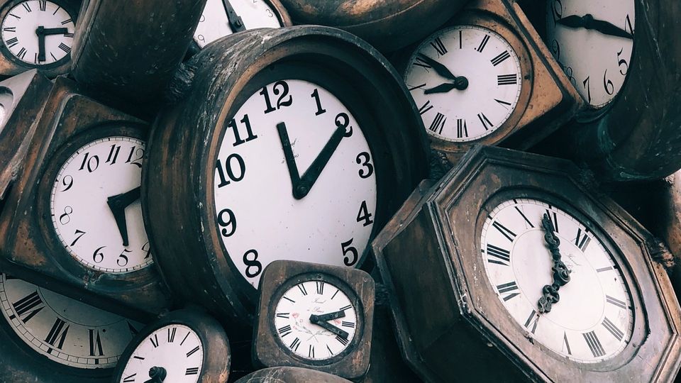 Collection of vintage analog clocks with different times displayed.