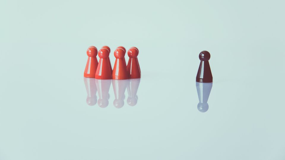 Red playing pieces cluster away from an isolated black piece.