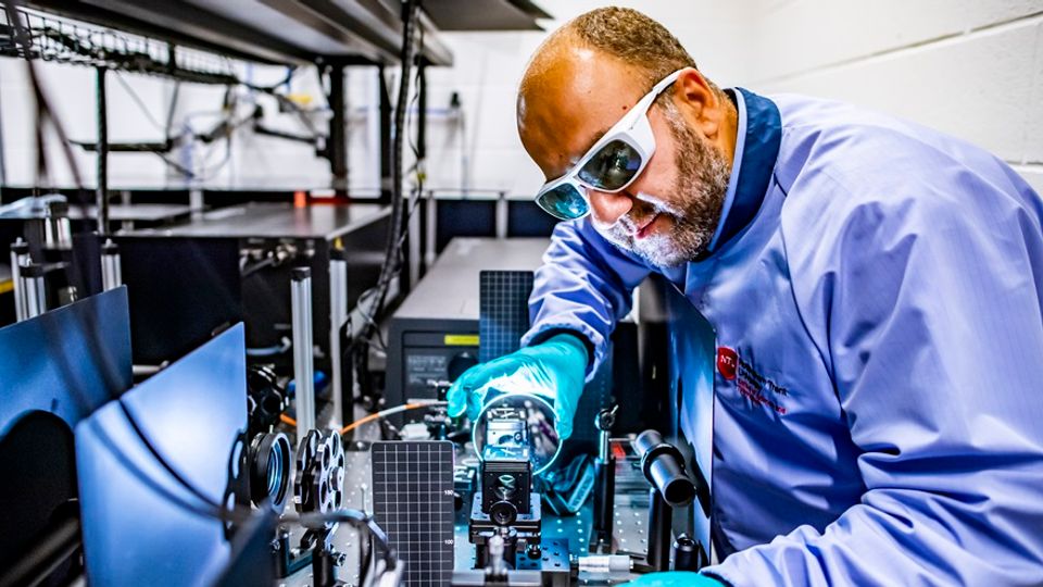 Professor Mohsen Rahmani in the Advanced Optics and Photonics (AOP) Lab, adjusting a piece of apparatus.