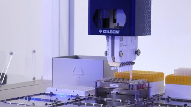 Automated Gilson liquid handling system pipetting samples into a 96-well plate in a laboratory. 
