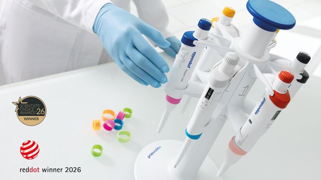 Researcher using Eppendorf electronic pipettes on a carousel stand for precise laboratory liquid handling. 
