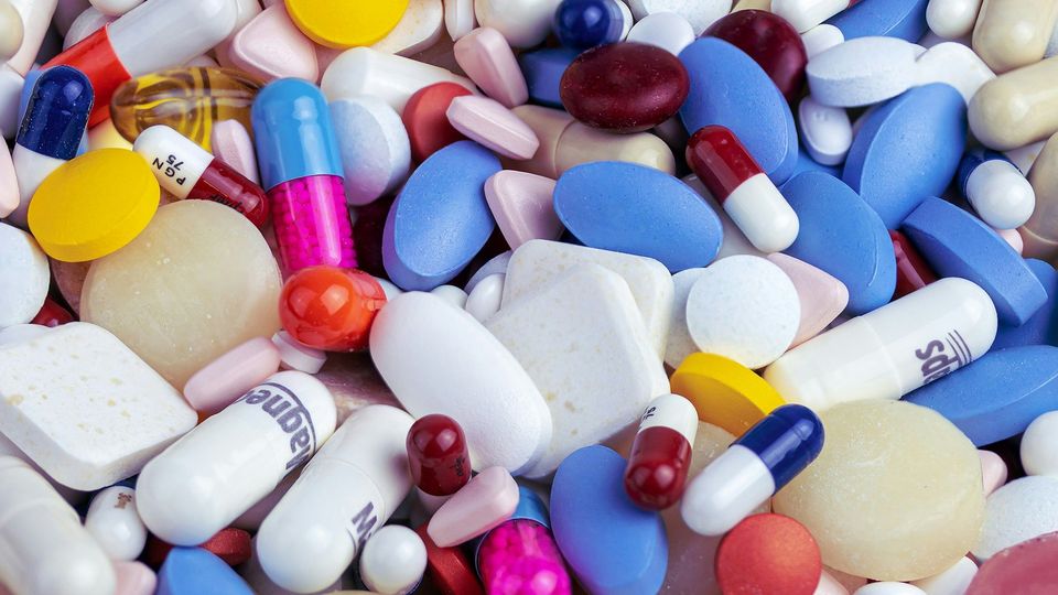 Assorted colorful pills, tablets, and capsules.