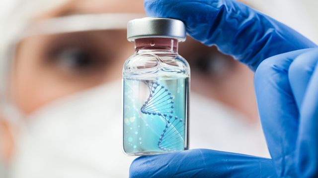 A scientist in PPE holding a vial containing a blue liquid and a DNA double helix. 
