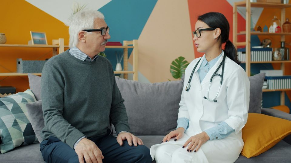 A doctor consults with an older patient.