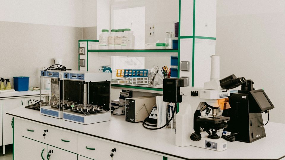 Modern laboratory with microscopes, analytical instruments, and research equipment on lab benches.