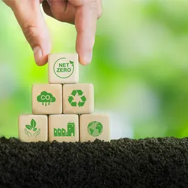 Sustainable GC and GC/MS performance illustrated with hand stacking net zero and recycling blocks on soil.