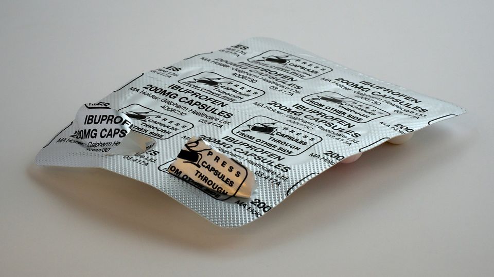 Ibuprofen blister pack placed on a flat white surface.