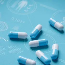 Blue and white capsules on a scientific medical background
