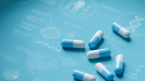Blue and white capsules on a scientific medical background